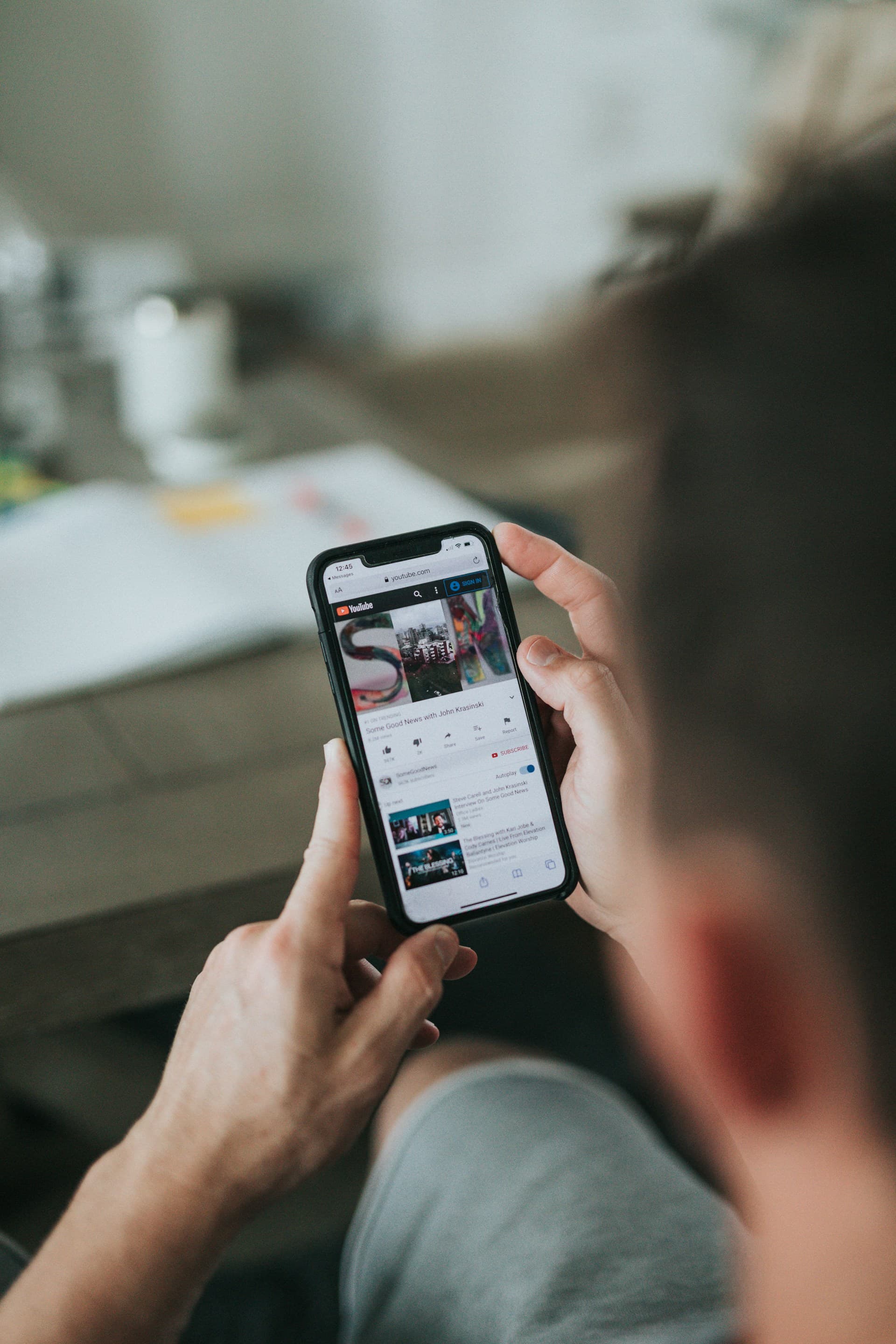 A man watching youtube on an iPhone