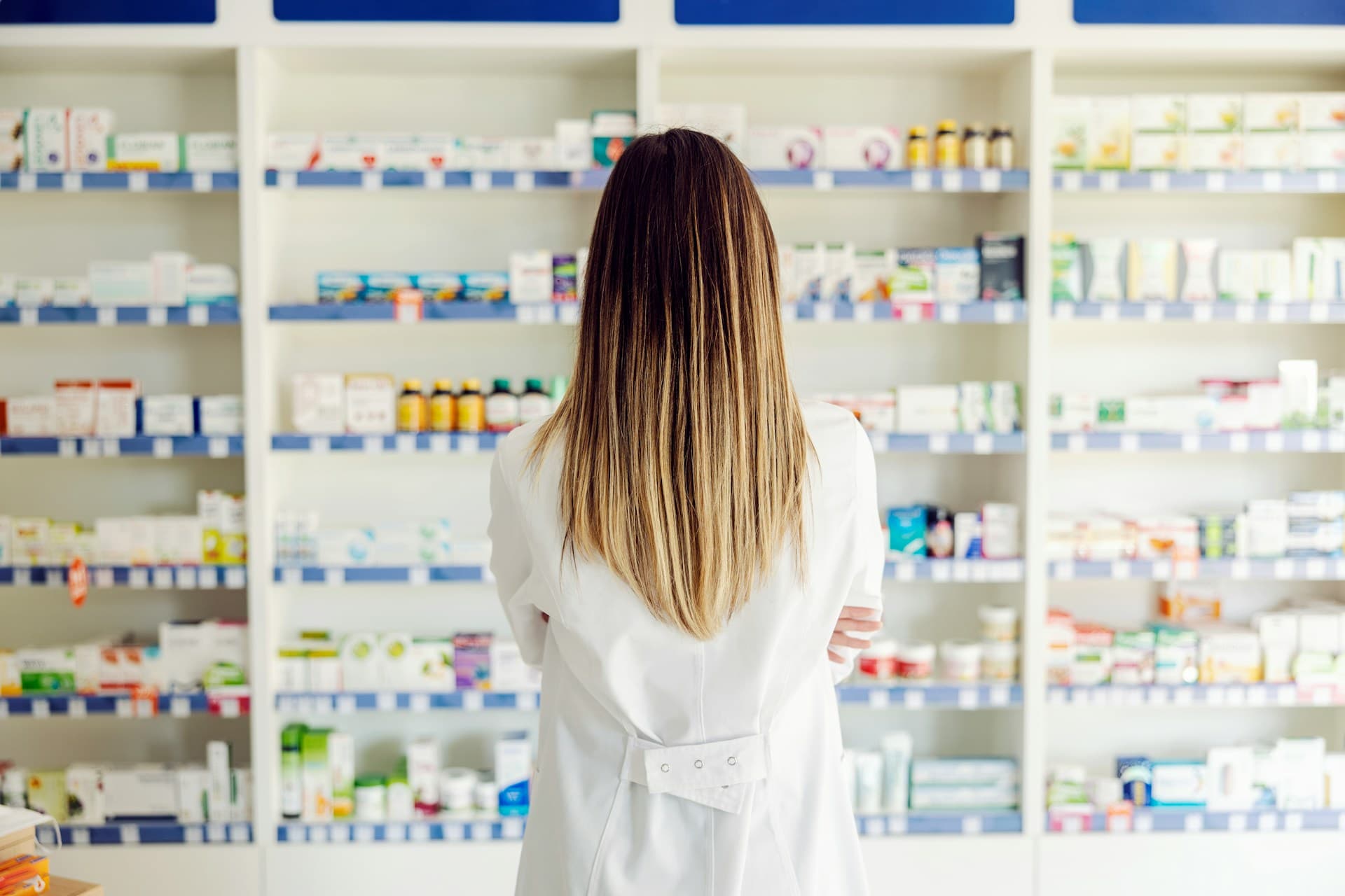 A woman standing in front of medicine shelves